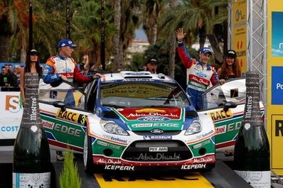 Mikko Hirvonen - Jarmo Lehtinen
47º RallyRACC Catalunya - Costa Daurada 2011. Ford Fiesta RS WRC (PX11 AWN). Clasificado 2º.

23-10-2011
Parque Cerrado Podium en Salou

Celebrando la segunda posición conseguida después que su compañero de Equipo Jari-Matti Latvala, penalizara en el control antes del Power Stage del Coll de la Teixeta SS18 de 4,32 Km.
Latvala se detuvo unos segundos antes de llegar a meta para favorecer a Mikko Hirvonen en el Campeonato del Mundo.

Del 20 al 23 de Octubre, Salou, Tarragona, Catalunya, España.
Superficie: asfalto - tierra.

El Rally tenia un total de 1589.90 km de los que 406.52 km divididos en 18 tramos eran especiales.

Tomaron la salida 58 equipos, finalizaron 44.
@
Palabras clave: Mikko_Hirvonen;Jarmo_Lehtinen;Ford;Fiesta;RS;WRC;Catalunya;2011;parque_cerrado