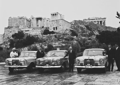 11º Acropolis Rally 1963
Equipo Oficial Mercedes
A la izquierda, el equipo femenino Ewy Rosqvist (vestimenta clara)-àšrsula Wirth (Mercedes 220-SE 2.2, 12º de la General).
En el centro, los ganadores de la prueba, Rolf Knoll (copiloto)-Eugen Böhringer (220-SE 2.2).
A la derecha, un joven Dieter Glemser, acompañado por su copiloto, Klaus Kà¡iser (el nuevo 300-SE 3.0), 5º de la General.
Con un peso de 1.450 kilos, los Mercedes, preparados en Gr. 2, desarrollan potencias entre los 165 CV (220-SE) y 200 CV (300-SE). Durante varios dà­as, Eugen Böhringer estuvo intimidado, a veces acorralado, por los Volvo 122-S 1.8 (120 CV/1.100 kilos) que intentaron desbancarlo sin conseguirlo. Dos de los equipos oficiales, suecos, acabaron por rendirse ante la manifiesta superioridad del Mercedes: Gunnar Andersson-Valter Karlsson (2º) y Carl-Magnus Skogh-Lars Berggren (3º). @
Palabras clave: Acropolis;Mujeres;Womens;Mercedes;1963;Parque_Cerrado