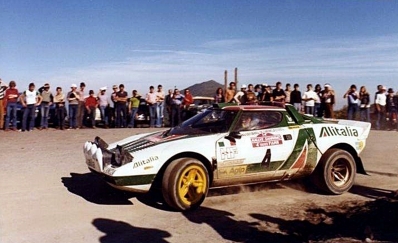 Björn Waldegard - Hans Thorszelius
18º Rally de San Remo 1976. Lancia Stratos HF (TO N12661). Clasificado 1º.

Cesare Fiorio, jefe del Equipo Lancia, manteniendo una conversación con Björn Waldegard.

Björn Waldegard estaba harto de las manipulaciones de Fiorio y su favoritismo en favor de Sandro Munari y así­ se lo hizo saber a Fiorio.
Waldegard mandaba el Rallye con 4 segundos de ventaja antes de tomar la salida en el último tramo del Rallye, Fiorio se puso delante del Stratos de Waldegard y lo retuvo durante 4 segundos después de que el comisario le hubiera dado la salida... y que ganara el mejor.... Waldegard ganó por 4 segundos a Munari.

La semana después de todo este jolgorio, Waldegard habló con Peter Ashcroft, director de Ford Motorsport, y firmó con ellos de cara a la temporada 1977. Cuando Fiorio negoció con Björn su contrato para 1977 y éste le dijo que ya habia firmado por Ford se cogió un cabreo monumental eliminando la inscripción de Waldegard para el Tour de Corse, que ya estaba formalizada.
Ashcroft, con su buena nariz en detectar buenas operaciones, se afanó en encontrar un patrocinio y preparar un Escort oficial para Waldegard y poder competir ese mismo año 76 en la última prueba del Mundial, el RAC Rally.

En el Tour de Corse no compitió pero en el RAC sí­ lo hizo ya con el Ford. Su resultado fue quedar por delante (3º) de Sandro Munari (4º a 54s).

Según dicen, Björn Waldegard se acerco a Fiorio al finalizar dicho Rally (RAC) y le dijo:
"Hasta con otro coche os gano"... repito, según dicen...

En una entrevista de primeros de 1980, recién proclamado Campeón del Mundo, Waldegard dijo, respecto a las órdenes de equipo:
"Nunca discuti­ esas órdenes, pero era la forma en que me eran comunicadas lo que no me gustaba".

Del 6 al 9 de Octubre, Sanremo, Imperia, Liguria, Italia.
Superficie: asfalto.

El Rally tenia un total de 1509 km de los que 780 Km divididos en 36 tramos eran especiales, (2 de ellos fueron cancelados SS9 y SS30).

Tomaron la salida 133 equipos, finalizaron 68.
@
Palabras clave: ;Hans_Thorszelius;Lancia;Stratos;Sanremo;1976