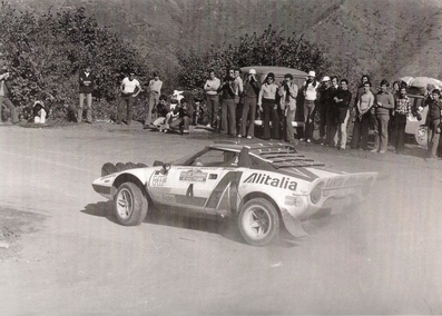 Björn Waldegard - Hans Thorszelius
18º Rally de San Remo 1976. Lancia Stratos HF (TO N12661). Clasificado 1º.

Cesare Fiorio, jefe del Equipo Lancia, manteniendo una conversación con Björn Waldegard.

Björn Waldegard estaba harto de las manipulaciones de Fiorio y su favoritismo en favor de Sandro Munari y así­ se lo hizo saber a Fiorio.
Waldegard mandaba el Rallye con 4 segundos de ventaja antes de tomar la salida en el último tramo del Rallye, Fiorio se puso delante del Stratos de Waldegard y lo retuvo durante 4 segundos después de que el comisario le hubiera dado la salida... y que ganara el mejor.... Waldegard ganó por 4 segundos a Munari.

La semana después de todo este jolgorio, Waldegard habló con Peter Ashcroft, director de Ford Motorsport, y firmó con ellos de cara a la temporada 1977. Cuando Fiorio negoció con Björn su contrato para 1977 y éste le dijo que ya habia firmado por Ford se cogió un cabreo monumental eliminando la inscripción de Waldegard para el Tour de Corse, que ya estaba formalizada.
Ashcroft, con su buena nariz en detectar buenas operaciones, se afanó en encontrar un patrocinio y preparar un Escort oficial para Waldegard y poder competir ese mismo año 76 en la última prueba del Mundial, el RAC Rally.

En el Tour de Corse no compitió pero en el RAC sí­ lo hizo ya con el Ford. Su resultado fue quedar por delante (3º) de Sandro Munari (4º a 54s).

Según dicen, Björn Waldegard se acerco a Fiorio al finalizar dicho Rally (RAC) y le dijo:
"Hasta con otro coche os gano"... repito, según dicen...

En una entrevista de primeros de 1980, recién proclamado Campeón del Mundo, Waldegard dijo, respecto a las órdenes de equipo:
"Nunca discuti­ esas órdenes, pero era la forma en que me eran comunicadas lo que no me gustaba".

Del 6 al 9 de Octubre, Sanremo, Imperia, Liguria, Italia.
Superficie: asfalto.

El Rally tenia un total de 1509 km de los que 780 Km divididos en 36 tramos eran especiales, (2 de ellos fueron cancelados SS9 y SS30).

Tomaron la salida 133 equipos, finalizaron 68.
@
Palabras clave: ;Hans_Thorszelius;Lancia;Stratos;Sanremo;1976