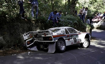 Henri Toivonen - Juha Piironen
18º Rallye de Portugal - Vinho do Porto 1984. Lancia Rally 037 (TO W67770). Abandonó por accidente en SS6 Sintra 2 de 10.50 Km.

Era su primera aparición en competición con el 037 en el Mundial. Su decepción y preocupación al salirse fue mayúscula, puesto que se jugaba un sitio en el Equipo Lancia.

Todos los aficionados que asistieron a la prueba ese año recuerdan el paso de Toivonen por los tramos de Portugal hasta el momento del accidente, como un grandioso espectáculo de valentí­a y manos, muchas, muchí­simas manos...

Un Toivonen en estado puro, demostrando dos cosas; por un lado que sus cualidades al volante no eran de este mundo, iba un paso más allá, no sólo en valentía si no también en técnica; y por otro lado que no sabia medir riesgos o mejor dicho, despreciaba y se pasaba por alto los límites de su 037, iba tan al lí­mite que su paso dejaba un murmullo de absoluta admiración entre los aficionados, pero al mismo tiempo una pregunta en el aire...

¿Hasta donde conseguirá llegar a ese ritmo absolutamente infernal y sobrehumano?.
La respuesta no tardaría en llegar, Sintra 2. 
Parte final embutida entre paredes y taludes, curva rápida en rasante, el Lancia despegó cual caza de combate en el punto de no retorno, se le acabo el asfalto y rozó el talud exterior perdiendo el control de su 037 rebotando de lado a lado o lo que es lo mismo de talud en talud.

Cesare Fiorio, ante la pregunta de un periodista que le preguntó si estaba enfadado por la salida de Toivonen, respondió:
"Para nada, todos vimos el gran potencial del coche y de Henri Toivonen !!".

Del 6 al 10 de Marzo, Estoril, Cascais, Lisboa, Portugal.
Superficie: asfalto - tierra.

El Rally tenia un total de 2400.00 km de los que 685.00 km divididos en 45 tramos eran especiales.

Se inscribieron 79 equipos, tomaron la salida 70, finalizaron 20.@

© Martin Holmes
@
Palabras clave: Henri_Toivonen;Juha_Piironen;Lancia;Grupo_B;Portugal;1984;Crash