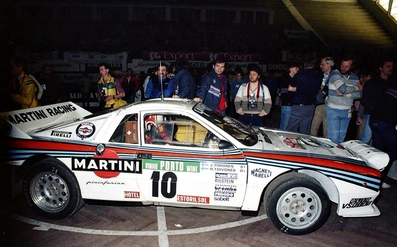 Henri Toivonen - Juha Piironen
18º Rallye de Portugal - Vinho do Porto 1984. Lancia Rally 037 (TO W67770). Abandonó por accidente en SS6 Sintra 2 de 10.50 Km.

Era su primera aparición en competición con el 037 en el Mundial. Su decepción y preocupación al salirse fue mayúscula, puesto que se jugaba un sitio en el Equipo Lancia.

Todos los aficionados que asistieron a la prueba ese año recuerdan el paso de Toivonen por los tramos de Portugal hasta el momento del accidente, como un grandioso espectáculo de valentí­a y manos, muchas, muchí­simas manos...

Un Toivonen en estado puro, demostrando dos cosas; por un lado que sus cualidades al volante no eran de este mundo, iba un paso más allá, no sólo en valentía si no también en técnica; y por otro lado que no sabia medir riesgos o mejor dicho, despreciaba y se pasaba por alto los límites de su 037, iba tan al lí­mite que su paso dejaba un murmullo de absoluta admiración entre los aficionados, pero al mismo tiempo una pregunta en el aire...

¿Hasta donde conseguirá llegar a ese ritmo absolutamente infernal y sobrehumano?.
La respuesta no tardaría en llegar, Sintra 2. 
Parte final embutida entre paredes y taludes, curva rápida en rasante, el Lancia despegó cual caza de combate en el punto de no retorno, se le acabo el asfalto y rozó el talud exterior perdiendo el control de su 037 rebotando de lado a lado o lo que es lo mismo de talud en talud.

Cesare Fiorio, ante la pregunta de un periodista que le preguntó si estaba enfadado por la salida de Toivonen, respondió:
"Para nada, todos vimos el gran potencial del coche y de Henri Toivonen !!".

Del 6 al 10 de Marzo, Estoril, Cascais, Lisboa, Portugal.
Superficie: asfalto - tierra.

El Rally tenia un total de 2400.00 km de los que 685.00 km divididos en 45 tramos eran especiales.

Se inscribieron 79 equipos, tomaron la salida 70, finalizaron 20.@

Palabras clave: Henri_Toivonen;Juha_Piironen;Lancia;Grupo_B;Portugal;1984;Parque_Cerrado