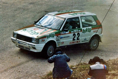 Giovanni Del Zoppo - Loris Roggia
20º Rallye de Portugal Vinho do Porto 1986. Fiat Uno Turbo (TO 32375D). Clasificado 3º.

Del 5 al 8 de Marzo, Estoril, Portugal.
Superficie: asfalto - tierra.

El Rallye tenía un total de 2428.47 km de los que 703.50 km divididos en 48 tramos eran especiales.

Todos los equipos "top" abandonan la prueba a causa del fatal accidente de Joaquim Santos y su Ford RS200 donde fallecieron 3 personas y muchas otras resultaron heridas de mayor y menor gravedad.

Todos los pilotos estaban indignados con el comportamiento del público, irresponsable y peligroso.
Hay que decir que habí­a público de todas las nacionalidades, pasó en Portugal como podrí­a haber pasado en cualquier otro Rallye del sur de Europa.

Henri fue quien comunicó a la prensa la unánime decisión de los pilotos.

Nueve tramos especiales fueron cancelados.
Los tres primeros una vez comenzados, (anulando los tiempos de todos los que habían terminado el tramo), SS1 Lagoa Azul 1 de 5.00 km, donde sucedió el accidente, SS2 Peninha1 de 6.50 km, SS3 Sintra 1 de 10.50 km, SS4 Lagoa Azul 2 de 5.00 km, SS5 Peninha 2 de 6.50 km, SS6 Sintra 2 de 10.50 km, SS7 Lagoa Azul 3 de 5.00 km, SS8 Peninha 3 de 6.50 km, SS9 Sintra 3 de 10.50 km.

Tomaron la salida 111 equipos, finalizaron 35.

Palabras clave: Fiat;Uno;Turbo;Portugal;1986