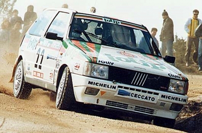 Giovanni Del Zoppo - Loris Roggia
20º Rallye de Portugal Vinho do Porto 1986. Fiat Uno Turbo (TO 32375D). Clasificado 3º.

Del 5 al 8 de Marzo, Estoril, Portugal.
Superficie: asfalto - tierra.

El Rallye tenía un total de 2428.47 km de los que 703.50 km divididos en 48 tramos eran especiales.

Todos los equipos "top" abandonan la prueba a causa del fatal accidente de Joaquim Santos y su Ford RS200 donde fallecieron 3 personas y muchas otras resultaron heridas de mayor y menor gravedad.

Todos los pilotos estaban indignados con el comportamiento del público, irresponsable y peligroso.
Hay que decir que habí­a público de todas las nacionalidades, pasó en Portugal como podrí­a haber pasado en cualquier otro Rallye del sur de Europa.

Henri fue quien comunicó a la prensa la unánime decisión de los pilotos.

Nueve tramos especiales fueron cancelados.
Los tres primeros una vez comenzados, (anulando los tiempos de todos los que habían terminado el tramo), SS1 Lagoa Azul 1 de 5.00 km, donde sucedió el accidente, SS2 Peninha1 de 6.50 km, SS3 Sintra 1 de 10.50 km, SS4 Lagoa Azul 2 de 5.00 km, SS5 Peninha 2 de 6.50 km, SS6 Sintra 2 de 10.50 km, SS7 Lagoa Azul 3 de 5.00 km, SS8 Peninha 3 de 6.50 km, SS9 Sintra 3 de 10.50 km.

Tomaron la salida 111 equipos, finalizaron 35.

 © António Teixeira.

Palabras clave: Fiat;Uno;Turbo;Portugal;1986