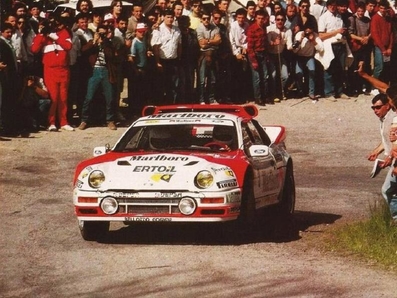 Antonio Zanini Sans - Josep Autet
10° Rally Villa de Llanes 1986. Ford RS 200 (2M 5557 P).
Marlboro Rally Team

Después de ir todo el rally peleando con Sainz (Renault 5 Maxiturbo / VA-4650-M) por la victoria, cuando quedaban dos tramos para el final y con la segunda plaza asegurada, apareció la lluvia en el tramo del Fito... Todos montaron ruedas de seco.

En la bajada del tramo se sale de la carretera Carlos Sainz, apareciendo poco después Antonio Zanini, que también se sale en la misma curva golpeando el Maxiturbo de Carlos.
Salvador Servià (Lancia Rally 037 / 2M 5511 P) consigue pasar por los pelos y por las indicaciones de Carlos Sainz para que aminorara la velocidad. Después de más de cuatro minutos, Antonio Zanini logra devolver el Ford, (que estaba apoyado al Maxiturbo de Carlos), a la carretera y continuar en carrera, quedando en 4ª posición final del Rally.

El 1 de Junio, Llanes, Asturias, España.
Superficie: asfalto.

Tomaron la salida 52 equipos, finalizaron 35.
@
Palabras clave: Ford;RS200;Villa_Llanes;1986;Grupo_B