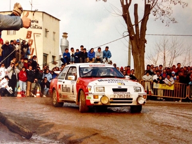Carlos Sainz - Antonio Boto
35º Rally Costa Brava 1987. Ford Sierra RS Cosworth (V-7853-BX). Abandonó por la rotura de la transmisión.

Polémica en torno a Sainz
Corrió cómo un reguero de pólvora la voz de que Sainz había sufrido un incidente con dos coches que venían de cara en pleno tramo, un vehículo de la Guardia Civil y otro de la organización, colisionando con uno de ellos.

Carmelo Ezpeleta, director del equipo Race-Marlboro, pedía la anulación del tramo y aseguraba que todo estaba muy claro, filmado desde el helicóptero que permanentemente seguía a Carlos Sainz para obtener tomas televisivas. Pasados los primeros instantes, la versión fue suavizándose, y aunque la organización, en este caso Juan Pons director de carrera, afirmaba que ambos coches estaban parados, Carmelo Ezpeleta aseguró que le habían admitido que bajaban en sentido contrario. lnsinuando una posible reclamación para anular el tramo justo en el momento en el que se supo que Carlos abandonaba definitvamente.

Carlos Sainz realizó una rueda de prensa, alabando la organización y lamentando este punto negro, más que nada porque representaba un grave peligro innecesario, asegurando que rompió la transmisión quizá por el golpe que había dado en la cuneta.

Curiosamente cuando llegó el helicóptero y descendió el cámara de vídeo, se le preguntó sobre el incidente sobre la filmación.
¿Qué incidente? Yo no he visto nada y no he podido filmar nada de esto porque no lo hemos visto. Es más, en el helicóptero nadie ha comentado nada sobre el tema, afirmó “Cherna” González, de Telesport, un cámara que seguía todos los rallyes del Mundial y los mejores de España.

Del 19 al 21 de Febrero, Lloret de Mar, Girona, Catalunya, España.
Superficie: asfalto - tierra.

Al año siguiente la prueba se fusionó con el Rally Catalunya pasando a llamarse Rally Catalunya-Costa Brava, por lo que la edición de 1988 se celebró bajo este nombre.

El Rally tenia un total de 1.139,5 Km con 27 tramos especiales.

Tomaron la salida 106 equipos, finalizaron 51.

© Pepe Santamaria
@
Palabras clave: ;Ford;Sierra;Cosworth;RS;Costa_Brava;1987