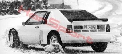 Audi Sport Quattro S2
En los 80 la colaboración entre Audi y Porsche era muy estrecha, ya que Ferdinand Piech nieto de Ferdinand Porsche, era el presidente de Audi y a la vez miembro de la familia propietaria de Porsche.
De ese modo no es extraño que gente de Porsche colaborase en la creacion, (que no en el desarrollo, y ahora me explico) del Audi motor central.

El coche no tuvo ningun tipo de desarrollo por que solo fue probado dos veces de manera breve y en absoluto secreto. Tan secreto era el proyecto que ni el propio Piech lo tenia muy claro y pensaba que solo se estaba trabajando en un prototipo, cuando en realidad se estaban construyendo 4 al mismo tiempo, (1 S2 y 3 RS002), y en lugares distintos.
Esto era así­ por que VW que era la mayor accionista de Audi, estaba pensando en cortar el grifo a Audi Sport por que los éxitos no llegaban y habí­a dado la orden de gastar solo en el desarrollo del S1 E2.

Tan secreta era la cosa que ni los pilotos oficiales tení­an conocimiento de la existencia del coche y fue un piloto de desarrollo del coches de calle el que probo en Desna el prototipo.

Fue una prueba simplemente para saber que todo estaba en su sitio y que el coche funcionaba correctamente. Una vez hecho esto se aviso a Rohrl de que tenia que hacer unas pruebas. Se busco una fecha en la que el piloto estuviese libre y para no tener que dar explicaciones del paradero de Rohrl se decidio hacer la prueba en Austria, lo mas cerca posible de Alemania, en unas pistas forestales cerca de Salzburgo. 
Ese dí­a aun de noche salieron dos camiones de Audi en dirección a Austria, pero al llegar al tramo se dieron cuenta que les habí­a seguido un coche con dos fotògrafos, así­ que dieron la vuelta y se fueron otra vez para Alemania sin bajar el coche del camión. Cruzaron la frontera y pararon los camiones y se aseguraron de que nadie los seguía.
Por la tarde se subieron otra vez a los camiones y muy cerca de allí en unos caminos de tierra de Baviera bajaron el coche y Rohrl pudo probarlo.
Hizo 180 km de Test y quedo convencido de que aquel coche era el arma definitiva para luchar de tu a tu con Peugeot y Lancia, de un plumazo se habí­an solucionado tanto los problemas de subviraje en curva lenta, como el comportamiento nervioso en zonas rápidas del S1 E2.

Pocos dí­as después sin saber como, ni quien las hizo, aparecieron fotos en un periódico Austriaco del coche. Tanto en la prueba de Desna como en la de Baviera... y todo se fue al garete.

Los de VW llamaron a Piech y lo pusieron fino, y éste se presento en los talleres de Audi Sport y descubrió que habí­a dos unidades mas diferentes con motor central a parte del que descubrió gracias a las fotos publicadas. 
El cabreo fue tal que mando destruir todas ellas en ese mismo instante y en su presencia. Hizo ir ha buscar una excavadora que estaba en el exterior de las instalaciones y ordenó que los aplastaran y posteriormente prensarlos.

Lo que no sabia Peich y por supuesto nadie se lo dijo, es que en Neckarsulm una planta de producción de Audi y en un almacén apartado estaba otra unidad del RS002 ya completamente terminada y con las fibras definitivas, y esa es la que esta en la actualidad expuesta en el museo Audi".
Palabras clave: Prototipo;Mundo_Rally_Retro;Audi;Quattro;Sport;Grupo_B;Grupo_S;1987